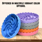 Stack of colorful silicone slow feeder dog bowl on a wooden surface with text about "offered in multiple vibrant color options".